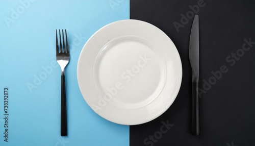 Empty wite plate on black and blue pastel background. Top view with copy space.