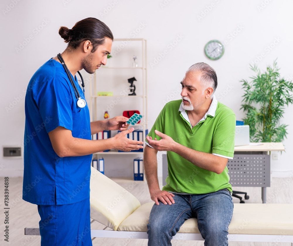 Fototapeta premium Old man visiting young male doctor gastroenterologist