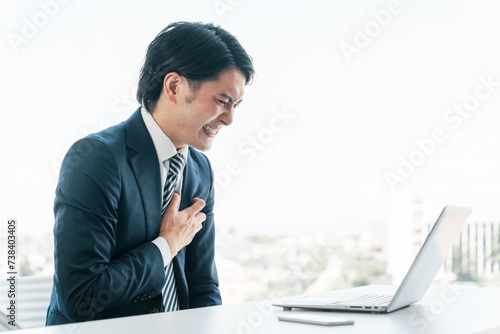 オフィスで胸を抑える若いアジア人ビジネスマン（心筋梗塞・発作・苦しい・急病・心臓発作・ストレス）
 photo