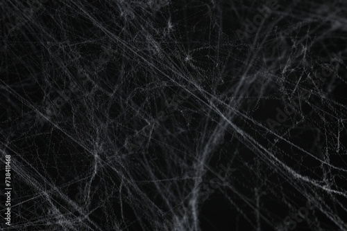 Creepy white cobweb on black background, closeup