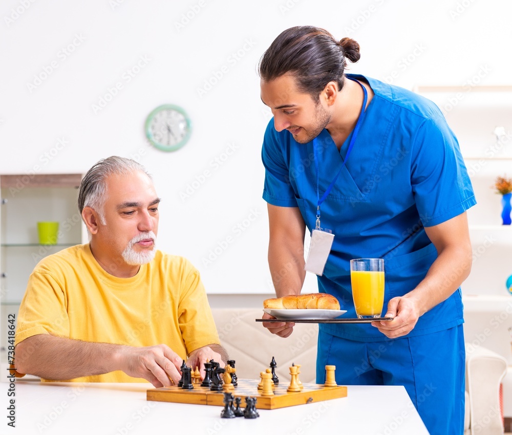 Young male doctor visiting old patient at home Young male doctor visiting old patient at home