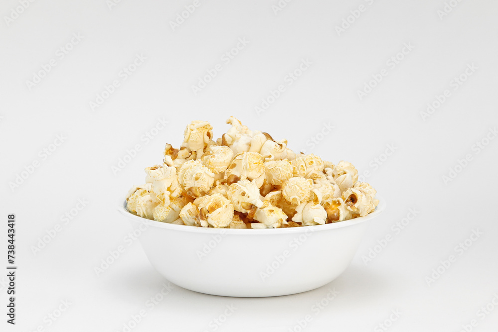 Small portion of popcorn in a white bowl with a white background Small portion of popcorn in a white bowl with a white background