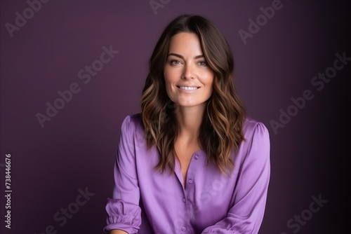 Portrait of a beautiful young woman in purple blouse on purple background
