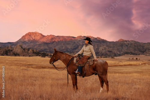 Photography Cowgirl on roan quarter horse in the mountains at sunrise alpenglow