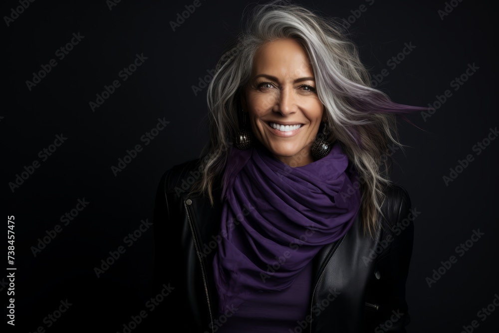 Portrait of a beautiful middle aged woman with long blond hair and a purple scarf.