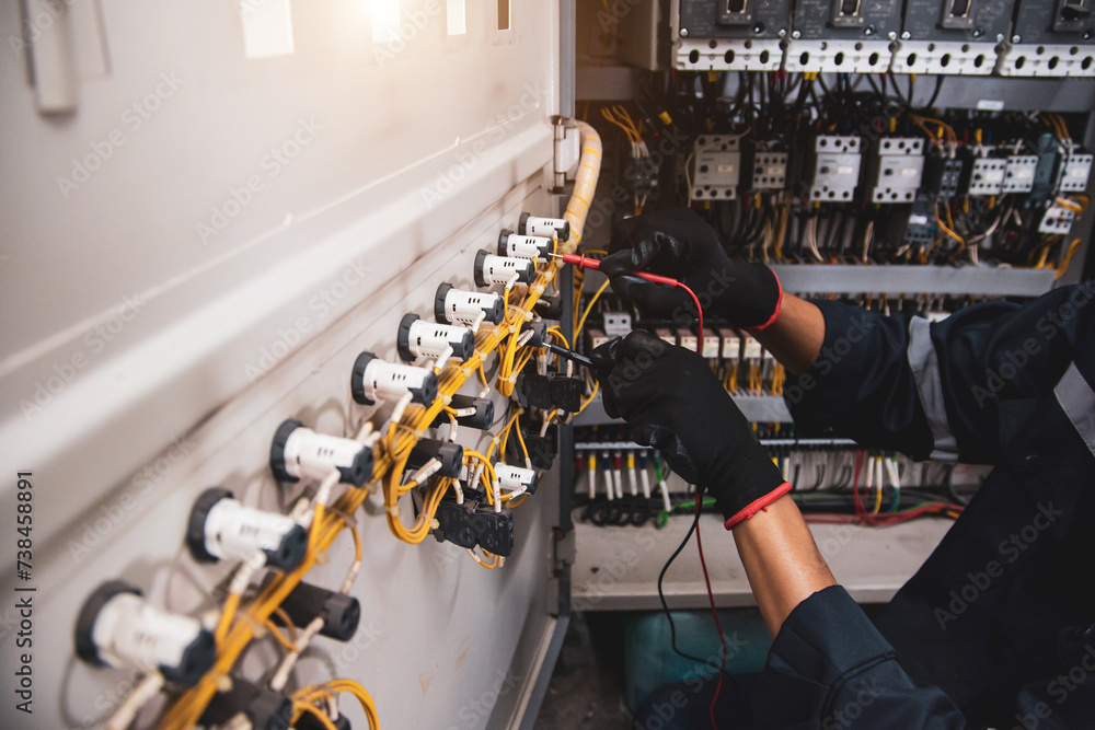 Electricity and electrical safety maintenance service system, Technician hand checking electric current voltage at circuit breaker terminal and cable wiring in main power distribution board. - obrazy, fototapety, plakaty 