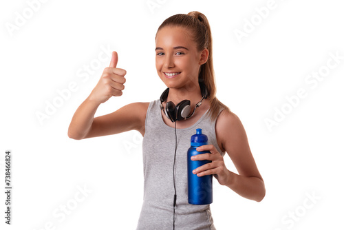 Young sporty young girl in sportswear with headset and water bottle showing thumbs up over white background