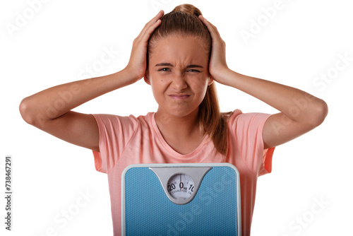 Teenager girl isolated on white background holding the weighing scale and covers ears with her hands