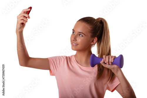 Portrait of beautiful young fit girl making selfie with smartphone and holding dumbbells isolated on white background