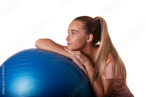 attractive and fit teen girl laying on a swiss blue ball in profile. Shot on white background