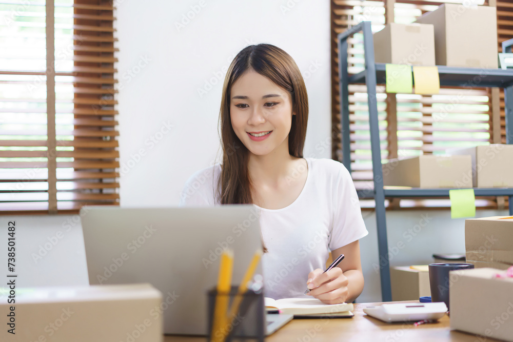 Online business concept, Asian business women checking purchase online orders and taking notes Online business concept, Asian business women checking purchase online orders and taking notes