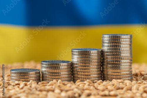 Growing money in the form of a stack of coins on the background of the Ukrainian flag and grain. Wheat price, grain reserves around the world. Food crisis. Export Logistics Solution