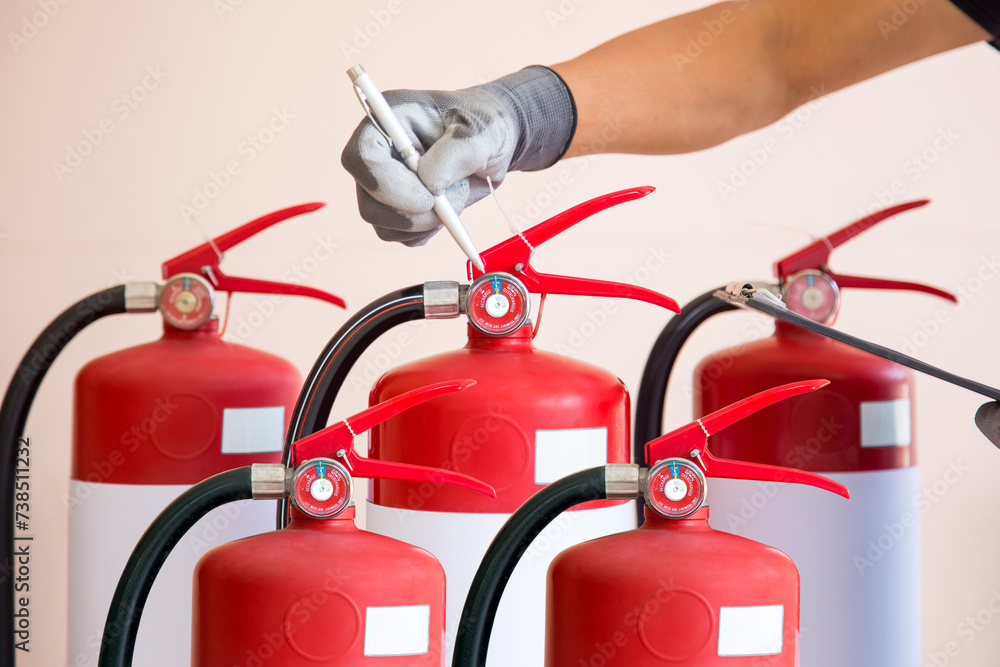 Hand checking fire extinguisher for fire prevention protection and prevent and safety rescue or use of equipment on fire training concept. Hand checking fire extinguisher for fire prevention protection and prevent and safety rescue or use of equipment on fire training concept.