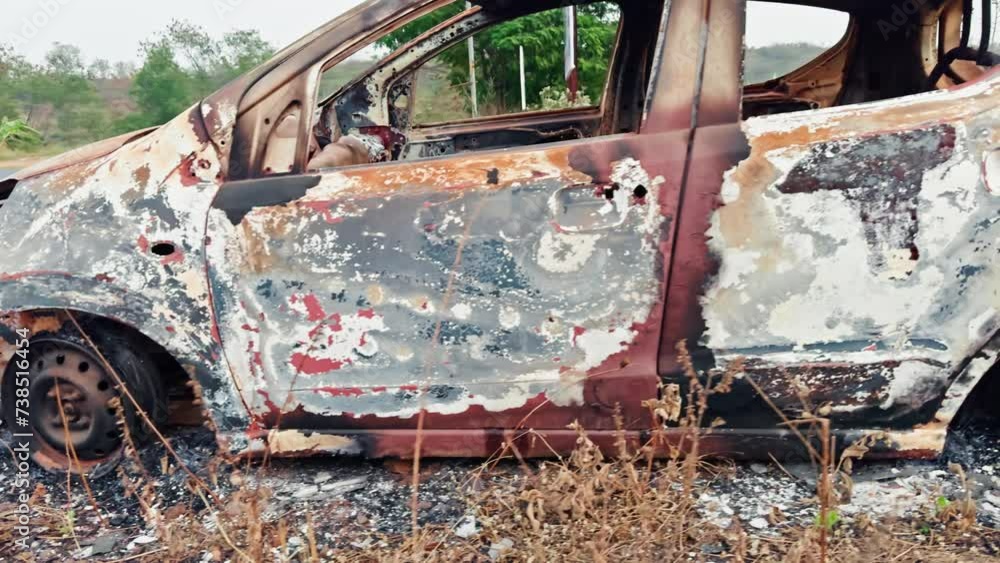 Burnt and abandoned car wreck on the side of the road showing rust and damage from fire after accident on highway parked roadside Burnt and abandoned car wreck on the side of the road showing rust and damage from fire after accident on highway parked roadside
