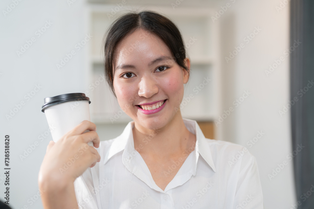 A beautiful woman goes to work with coffee, walking near an office building. Image of a successful businesswoman holding a cup of hot drink on her way to work on a city street. High resolution A beautiful woman goes to work with coffee, walking near an office building. Image of a successful businesswoman holding a cup of hot drink on her way to work on a city street. High resolution