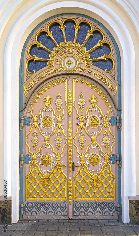 A gilded door decorated with exquisite carvings, the entrance to one of the boundaries of the Pochaev Lavra. View Pochaev Lavra to Pochaev, a city in western Ukraine.