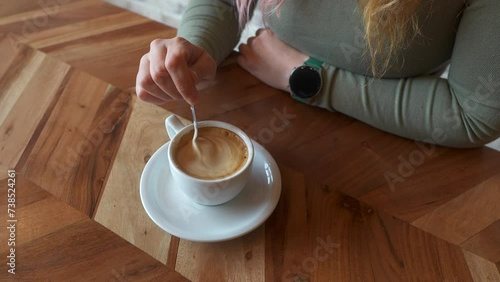 Overhead view of a woman's hand with a coffee cup  photo