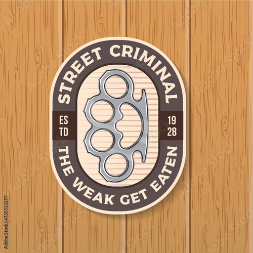 The weak get eaten. Classic gangster patch, sticker design. Vector illustration. Vintage monochrome label, sticker, patch with knuckle duster silhouette.
