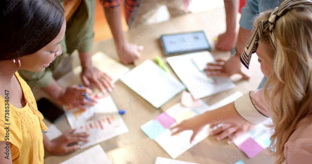 A diverse team collaborates in a casual business, bright office setting A diverse team collaborates in a casual business, bright office setting