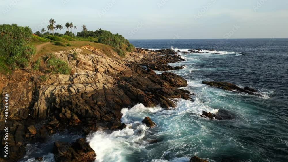 Tropical rocky coast with jungles and palms trees washing with crushing waves Tropical rocky coast with jungles and palms trees washing with crushing waves