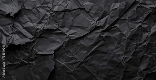 A black rolled paper texture with wrinkles, captured in a matte photo, appearing crumpled.