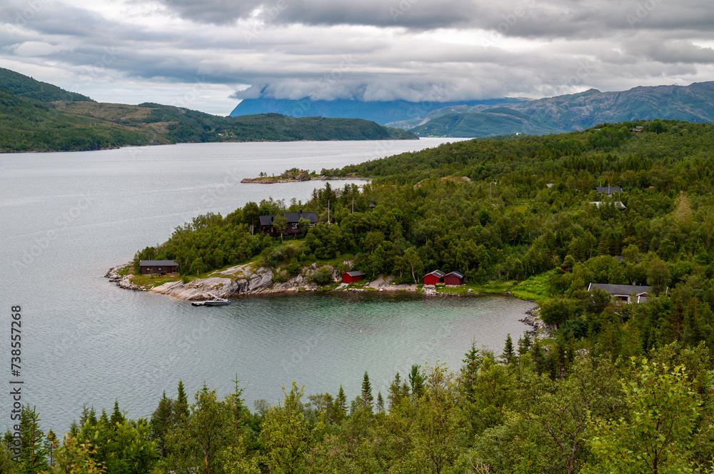 A bay in a fjord in Norway with mountains and forests on the sea coast.