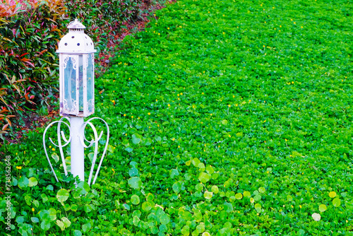 Lantern in the garden with green grass background, Thailand.