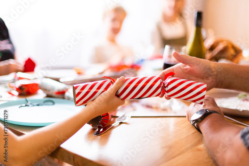 red and white Christmas cracker bon bon with child and adult hands