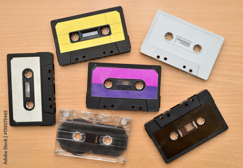 Obraz premium Old cassette tapes collection on the brown wooden table. Vintage technology concept. Top view.