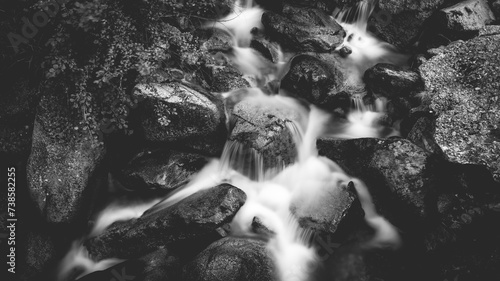 Ceresole Reale, Italy. Small waterfalls between the rocks of a mountain stream, near the Dres waterfall near Lake Ceresole. Concept of pristine nature, pure water, flowing water, source of life.
