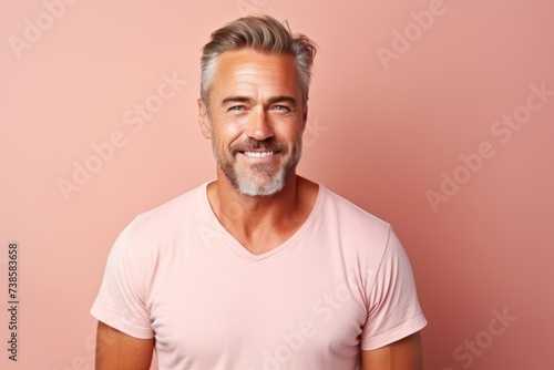 Portrait of a handsome middle-aged man smiling against pink background