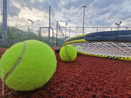  yellow tennis balls and racquet on hard tennis court surface, top view tennis scene photo