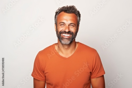 Portrait of a smiling middle-aged man in orange t-shirt.