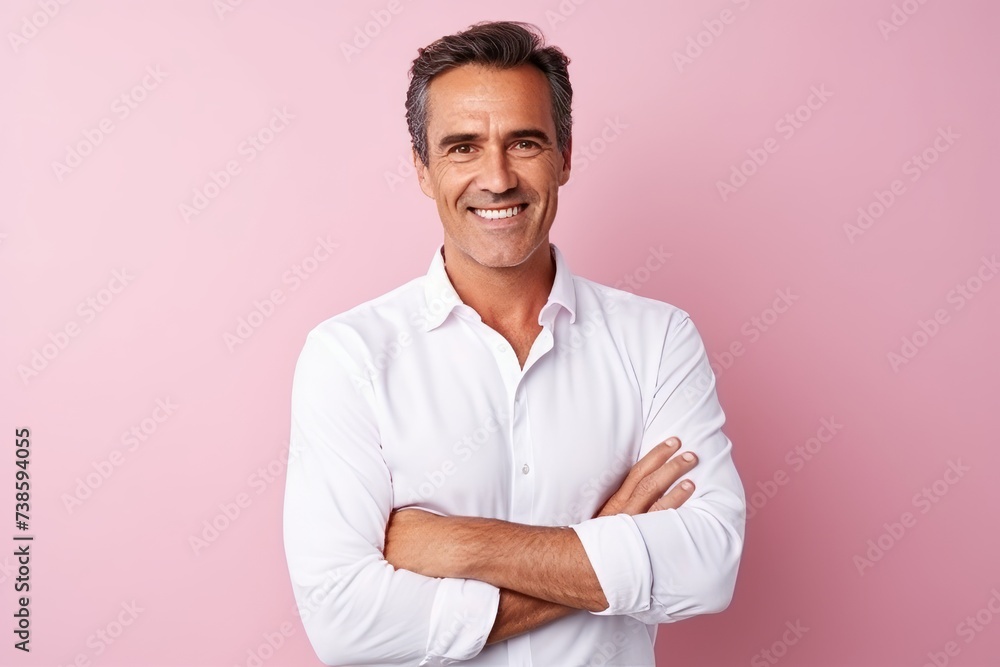Portrait of a handsome mature man with arms crossed against pink background Portrait of a handsome mature man with arms crossed against pink background