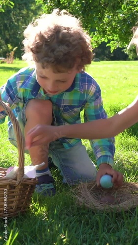 Two children boy and girl having easter egg hunt in garden backyard