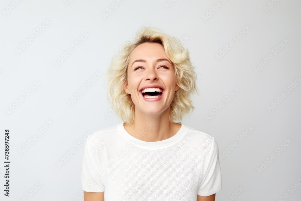 Portrait of a happy middle-aged woman laughing against white background Portrait of a happy middle-aged woman laughing against white background