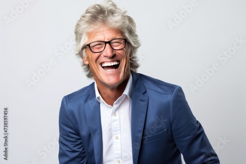 Portrait of a happy senior businesswoman laughing on a gray background