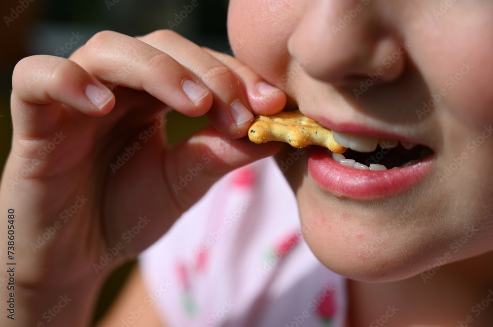 Young girl - child eating candy and sweets. Detail of face and mouth. Concept for healthy lifestyle - healthy - unhealthy sweet food and sugar. Young girl - child eating candy and sweets. Detail of face and mouth. Concept for healthy lifestyle - healthy - unhealthy sweet food and sugar.