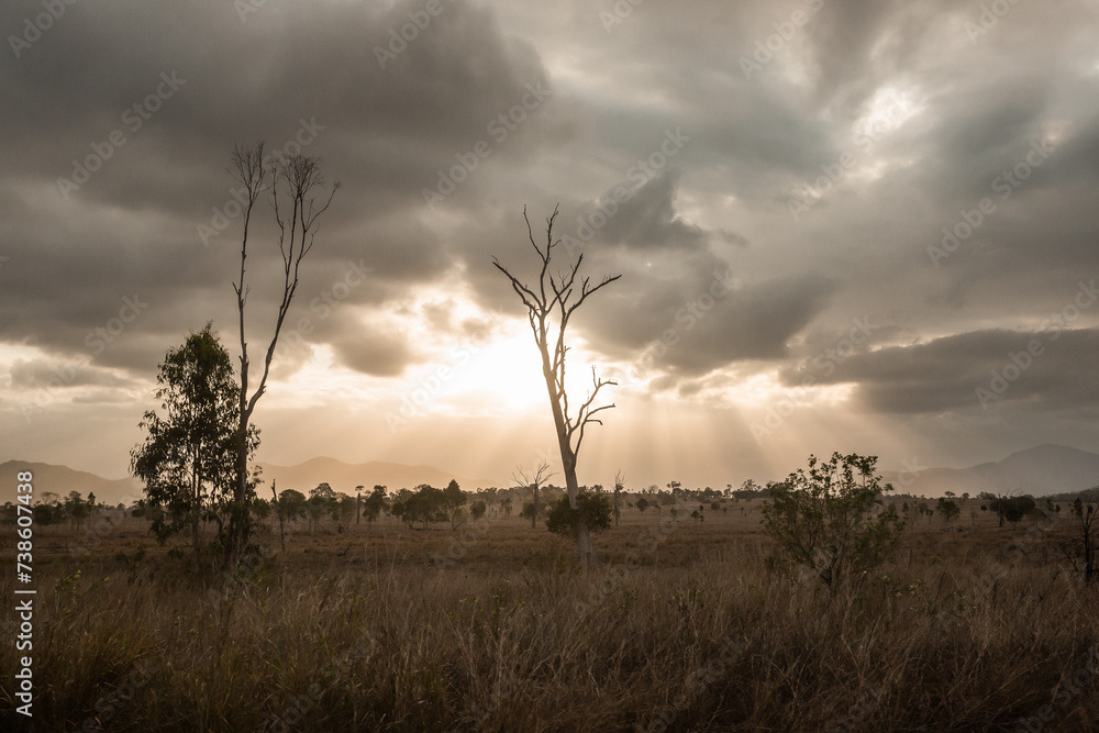 dramatic sun light streaming through clouds over farmland dramatic sun light streaming through clouds over farmland
