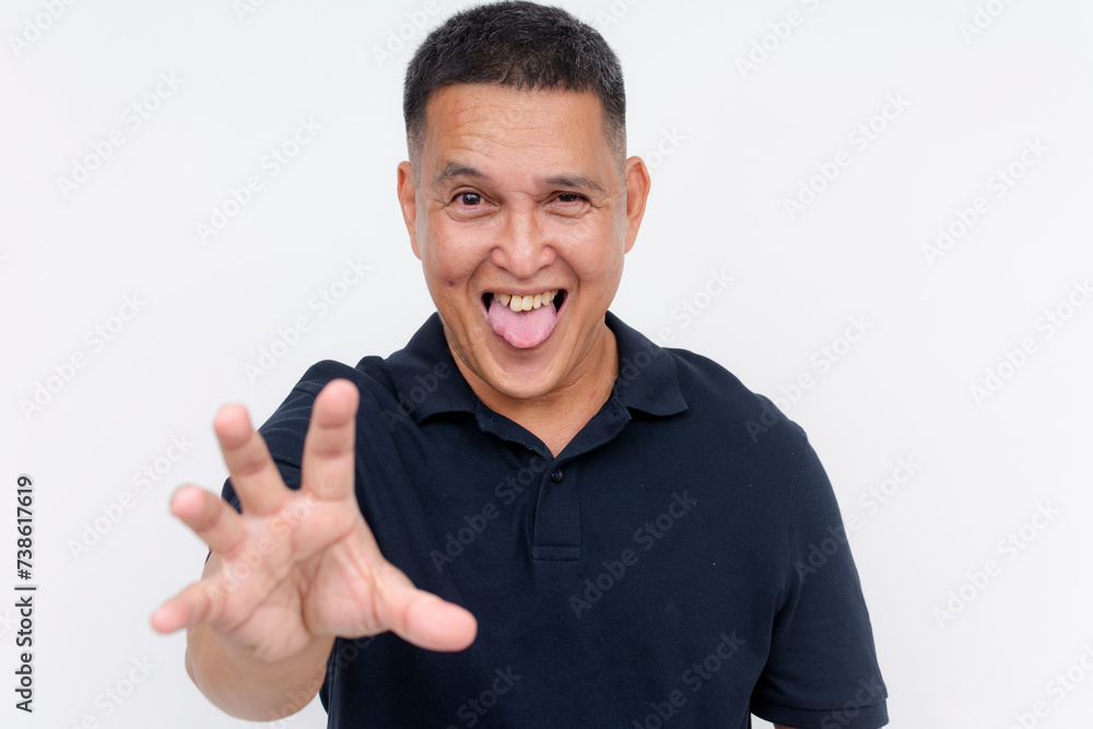 Playful and energetic middle-aged Asian man reaching towards the camera with his tongue out, isolated on a white background.