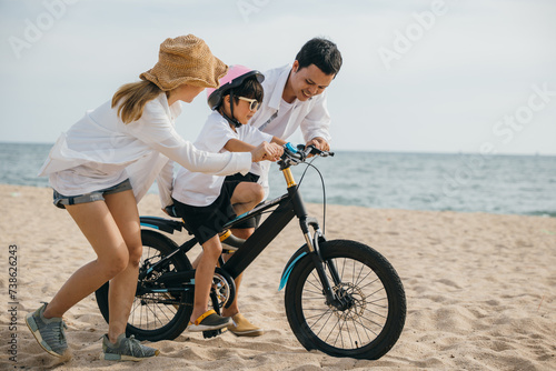 A picturesque sunset scene on sandy beach as parents teach their children joy of bicycle riding during summer road trip. Smiles balance and carefree happiness define this memorable family moment.