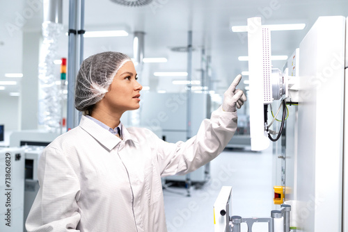 Female technologist worker controlling production process in electronic manufacturing factory.