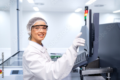 Portrait of experienced female worker operating production process inside modern factory.