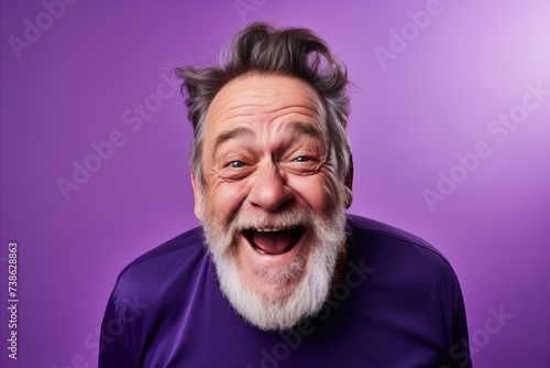 Surprised senior man with long white beard and mustache on purple background © Loli