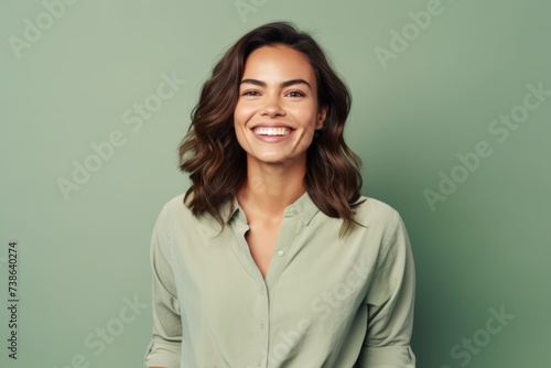 Portrait of happy young woman smiling at camera, over green background