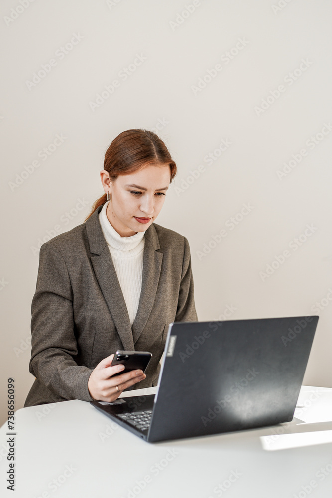 a beautiful woman in a gray suit works at a laptop a beautiful woman in a gray suit works at a laptop