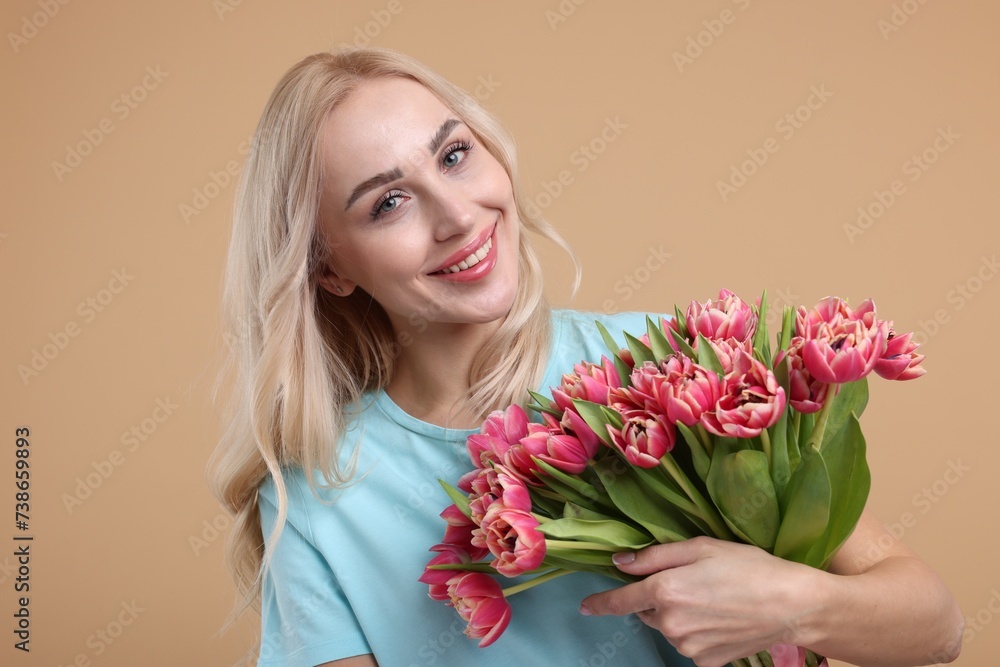 Happy young woman with beautiful bouquet on beige background Happy young woman with beautiful bouquet on beige background