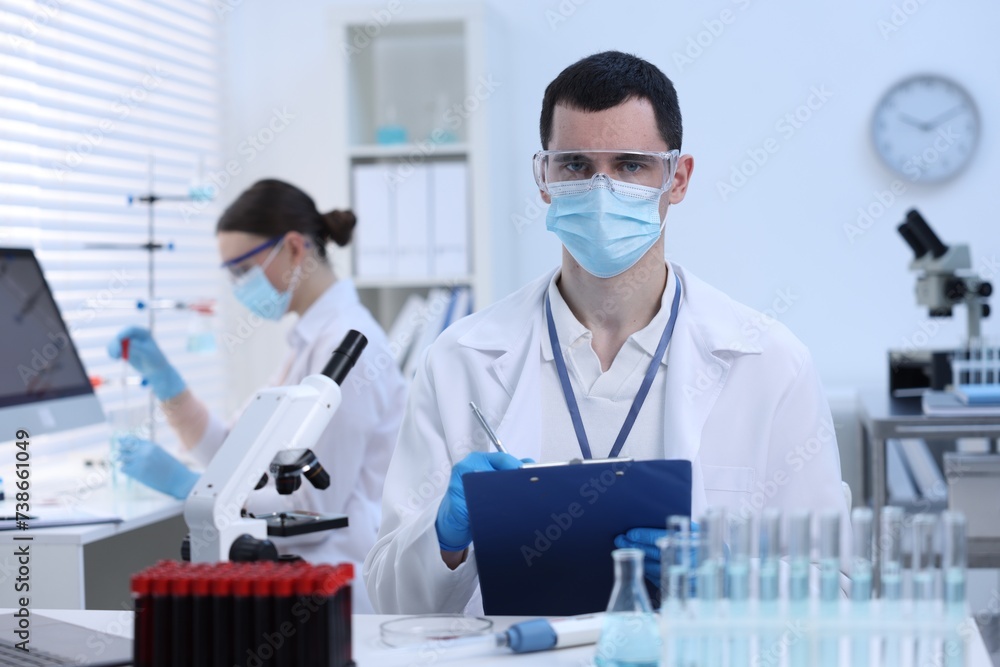 Scientist working with laboratory test form at table indoors Scientist working with laboratory test form at table indoors