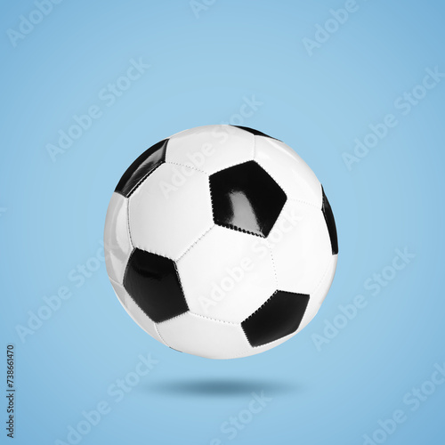 One soccer ball in air on light blue background