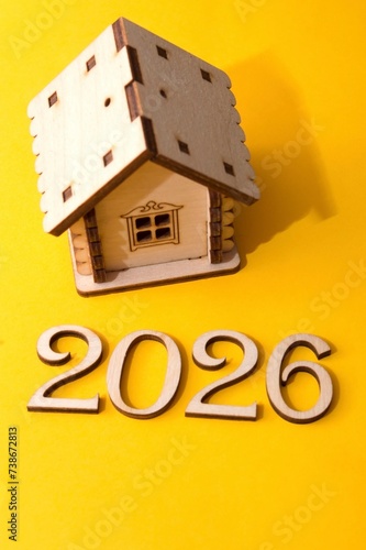A house on a yellow background with the numbers of the year 2026